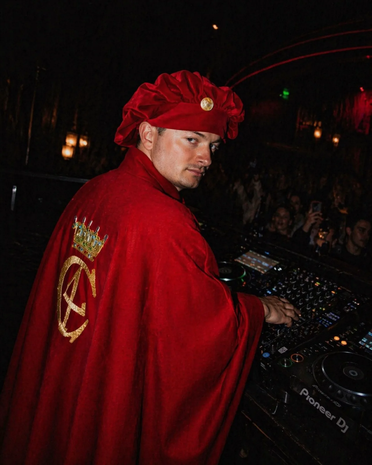 Julius Sylvest at the DJ booth in a red costume during a live performance.